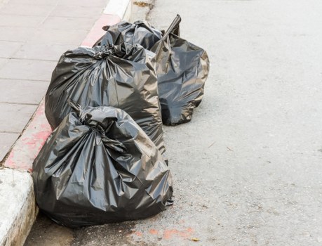 Operatives using safe tools during garden waste removal