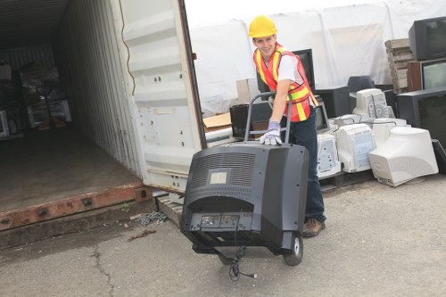 Workers loading green waste into a van for garden clearance